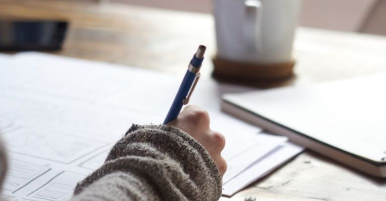 Mujer escribiendo con bolígrafo